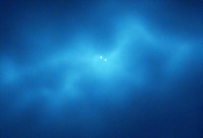 The primary subject of the image is a blue sky with two bright stars in the middle of it. The setting is a cloudy sky, and the visual style appears to be a photo. The dominant colors are blue and white, creating a calm and serene atmosphere.