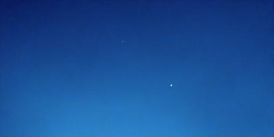 Primary subject: The main object of the image is a blue sky with a few stars visible.

Setting/background: The sky is the primary background of the image, with no other objects or landscapes visible.

Visual style: The image is a photo of the night sky, showcasing the stars and the vast expanse of the blue sky.

Colors and mood: The dominant colors in the image are blue and white, with the blue sky creating a calm and serene atmosphere. The presence of stars