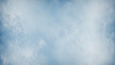 The primary subject of the image is a blue sky with clouds. The setting is a cloudy day, and the visual style is a natural, outdoor scene. The colors and mood of the image are predominantly blue and calm, creating a serene atmosphere.