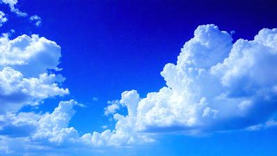 The primary subject of the image is a cloudy blue sky with a few white clouds. The setting is a clear day with a blue sky, and the visual style is a natural, outdoor scene. The colors and mood of the image are predominantly blue and serene, creating a peaceful atmosphere.