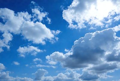 The primary subject of the image is a cloudy blue sky filled with various cloud formations. The setting is an open sky, and the visual style is a natural, outdoor scene. The colors and mood of the image are predominantly blue and cloudy, creating a serene and peaceful atmosphere.