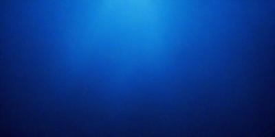 The primary subject of the image is a large body of water, which appears to be a deep blue ocean. The setting is a vast expanse of water, with no visible land or other objects. The visual style of the image is a photo, capturing the natural beauty of the ocean. The dominant colors in the image are the deep blue of the water and the darkness of the surrounding environment. The overall atmosphere of the image is serene and peaceful, as it showcases the vastness and tranquility of the ocean.