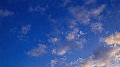 The primary subject of the image is the sky, which is filled with clouds. The setting is a clear blue sky, and the visual style is a photo. The colors in the image are predominantly blue and white, creating a calm and serene atmosphere.