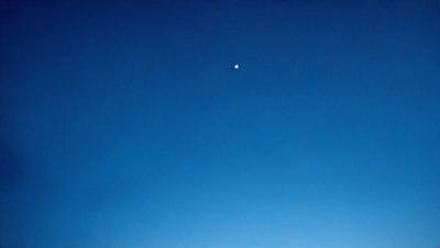 The primary subject of the image is the night sky, which is filled with stars. The setting is a clear, dark night with a blue sky. The visual style is a photo, capturing the beauty of the night sky. The colors and mood of the image are predominantly blue, creating a serene and peaceful atmosphere.