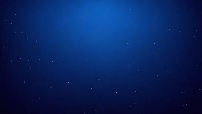 The primary subject of the image is a blue sky filled with stars. The setting is a dark, star-filled sky, which creates a sense of depth and mystery. The visual style is a combination of a photo and digital art, as the image captures the beauty of the night sky with the stars. The colors and mood of the image are predominantly dark and serene, with the blue sky and stars creating a sense of tranquility and wonder.