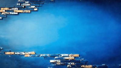 The primary subject of the image is a brick wall with a blue background. The setting appears to be a brick wall with a blue background, possibly in a city or urban environment. The visual style of the image is a photo, capturing the brick wall and its surroundings. The colors and mood of the image are predominantly blue, creating a calm and serene atmosphere.