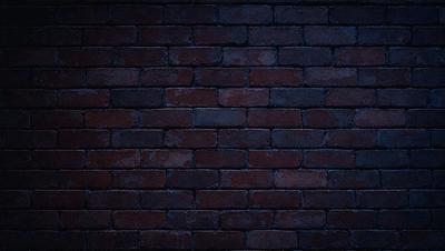 The primary subject of the image is a brick wall. The setting is a dark room, and the visual style is a photo. The dominant colors are red and brown, creating a warm and earthy atmosphere.