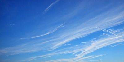 The primary subject of the image is the sky, which is filled with clouds. The setting is a clear blue sky, and the visual style is a photo. The clouds are white and scattered throughout the sky, creating a serene and peaceful atmosphere.
