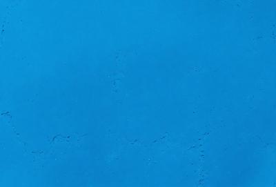 The primary subject of the image is a large, blue surface with a pattern of white dots. The setting appears to be a dark room, and the visual style is a close-up of the blue surface. The dominant colors are blue and white, creating a calm and serene atmosphere.