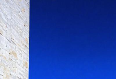 The primary subject of the image is a large building with a blue sky in the background. The setting is an outdoor environment, and the visual style appears to be a photo. The dominant colors in the image are blue and white, creating a calm and serene atmosphere.