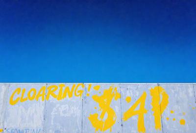 The primary subject of the image is a large yellow sign with the word "Daring!" written on it. The sign is positioned on a wall, and the setting appears to be an outdoor environment. The visual style of the image is a combination of a photo and digital art, as it features a yellow background and a bold, eye-catching design. The colors and mood of the image are energetic and adventurous, with the bright yellow sign standing out against the backdrop.