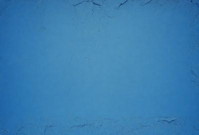 The primary subject of the image is a blue wall with a cracked and chipped surface. The setting is an indoor environment, possibly a room or a building. The visual style is a close-up of the blue wall, showcasing its texture and imperfections. The dominant colors are blue and white, creating a calm and serene atmosphere.