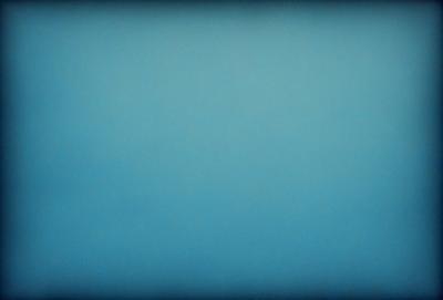 The primary subject of the image is a large, open, and empty blue sky. The setting is a vast, cloudless expanse, with no visible landmarks or objects. The visual style is a black and white photo, which adds a timeless and classic feel to the scene. The colors and mood are predominantly dark and moody, with the blue sky serving as the main focal point.