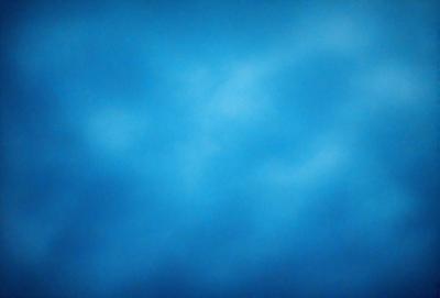 The primary subject of the image is a blue sky with clouds. The setting is a vast, open space with no visible landmarks or objects. The visual style is a natural, outdoor scene. The colors and mood are predominantly blue, creating a calm and serene atmosphere.
