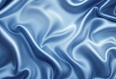 The primary subject of the image is a blue fabric with a silky texture. The setting is a blue background, which creates a visually appealing contrast with the fabric. The visual style is a close-up of the fabric, showcasing its intricate details. The colors and mood of the image are predominantly blue, giving it a calm and serene atmosphere.
