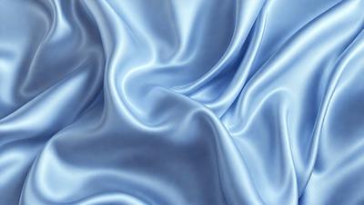 The primary subject of the image is a blue fabric, possibly a piece of silk, with a flowing and swirling pattern. The setting is a blue background, which complements the blue fabric. The visual style is a close-up of the fabric, showcasing its texture and pattern. The colors and mood of the image are predominantly blue, creating a calm and serene atmosphere.