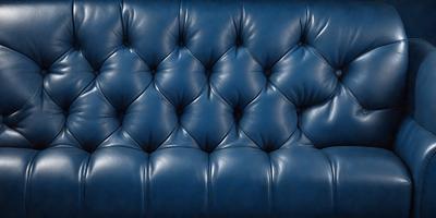 The primary subject of the image is a blue leather couch. The setting is a room with a blue background. The visual style is a photo, and the dominant colors are blue and black. The overall atmosphere is elegant and sophisticated.