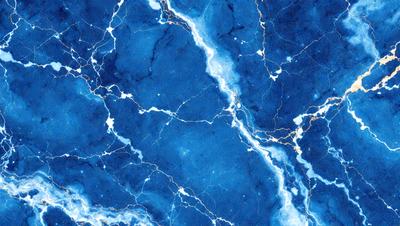The primary subject of the image is a blue marble wall with a pattern of white and gold streaks. The setting is a room with a blue marble floor, and the visual style is a close-up of the marble wall. The colors and mood of the image are predominantly blue and gold, creating a luxurious and elegant atmosphere.