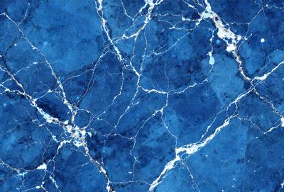 The primary subject of the image is a blue marble wall with a pattern of white and blue swirls. The setting is a room with a blue marble floor. The visual style is a close-up of the marble wall, showcasing the intricate pattern. The colors and mood of the image are predominantly blue, creating a calm and serene atmosphere.