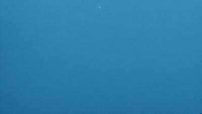 The primary subject of the image is a blue sky with a single dot in the middle. The sky is the setting, and it appears to be a natural, outdoor environment. The visual style of the image is a photo, capturing the beauty of the blue sky and the dot in the middle. The colors and mood of the image are predominantly blue, creating a calm and serene atmosphere.