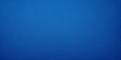 The primary subject of the image is a large, open, and empty blue sky. The setting is a vast, cloudless expanse, with no visible landmarks or objects. The visual style is a natural, untouched landscape, with no indication of digital manipulation or artistic elements. The colors and mood are predominantly blue, conveying a sense of tranquility and vastness.
