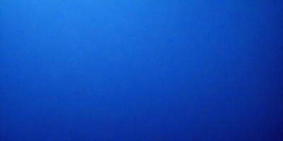 The primary subject of the image is a large, open, and dark blue sky. The setting is a vast, empty space with no visible landmarks or objects. The visual style is a natural, untouched, and unaltered representation of the sky. The colors and mood convey a sense of tranquility and vastness, as the blue sky stretches out into the distance.