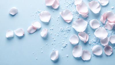 The primary subject of the image is a close-up of a pink flower petal. The setting is a blue background, which creates a contrasting and visually appealing effect. The visual style is a photo, capturing the beauty of the flower petal in detail. The dominant colors are pink and blue, creating a serene and calming atmosphere.