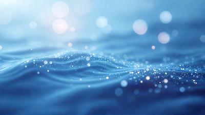 The primary subject of the image is a blue ocean with a few white sparkles or bubbles floating on the surface. The setting is the ocean, and the visual style appears to be a photo of the water. The dominant colors are blue and white, creating a serene and calming atmosphere.