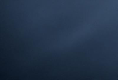 The primary subject of the image is a dark blue sky. The setting is a cloudy day, with the sky being the main focus of the image. The visual style is a natural, outdoor scene. The colors and mood of the image are predominantly dark and moody, with the blue sky being the only bright element in the scene.