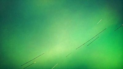 The primary subject of the image is a green sky with a few white streaks. The setting is a cloudy sky, and the visual style appears to be a digital art or illustration. The colors and mood of the image are predominantly green, with the white streaks adding a touch of contrast.