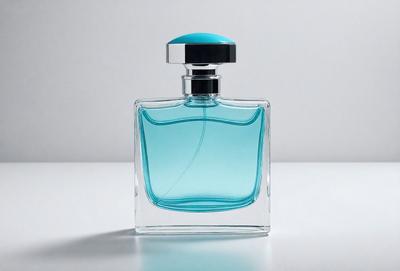 The primary subject of the image is a bottle of cologne, which is placed on a white surface. The setting is a simple background, and the visual style is a close-up of the bottle. The dominant colors in the image are blue and white, creating a clean and elegant atmosphere.