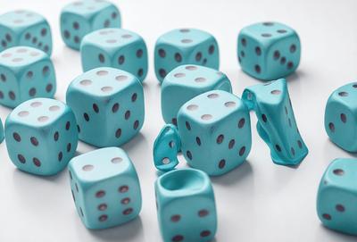 The primary subject of the image is a collection of blue and white dots, which are likely made of plastic. They are arranged on a white surface, creating a visually appealing and colorful display. The setting appears to be a table or a similar flat surface, providing a clean and uncluttered backdrop for the dots. The visual style of the image is likely a combination of photo and digital art, as the dots are arranged in a way that suggests a deliberate composition. The colors and mood of the