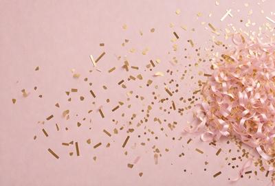 The primary subject of the image is a pink rose, which is the main focus of the scene. The rose is placed on a pink background, creating a visually appealing contrast. The visual style of the image is a combination of photo and digital art, as it appears to be a close-up of the rose with a gold background. The colors and mood of the image are predominantly pink, which gives it a warm and inviting atmosphere.