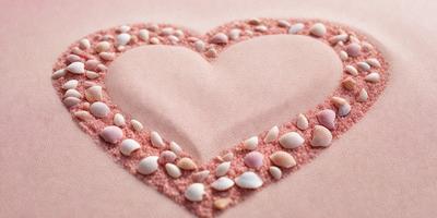 The primary subject of the image is a heart-shaped sand sculpture, which is made of sand and shells. The heart is placed on a pink surface, which adds a warm and inviting touch to the scene. The setting is a beach, with the sand sculpture being the main focus of the image. The visual style is a combination of digital art and illustration, as the heart is skillfully crafted and the sand and shells are realistically depicted. The colors and mood of the image are pre