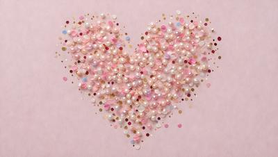 The primary subject of the image is a heart-shaped arrangement of pearls. The heart is made up of various pearls of different sizes, creating a visually appealing and elegant display. The setting is a pink background, which adds a touch of warmth and softness to the scene. The visual style of the image is a combination of digital art and illustration, as it showcases the intricate details of the pearls and the heart's shape. The colors and mood of the image are pre