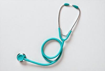 The primary subject of the image is a stethoscope, which is a medical device used by doctors and nurses to listen to a patient's heart and lung sounds. The stethoscope is blue and has a silver ring around the top. The setting is a white background, which provides a clean and uncluttered look to the image. The visual style is a close-up of the stethoscope, allowing the viewer to focus on the details of the device. The colors and mood of the