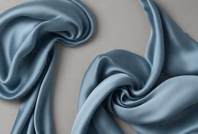 The primary subject of the image is a blue fabric, which is the main object, scene, or focus of the image. The setting is a gray background, which provides a contrasting environment for the blue fabric. The visual style of the image is a digital art, as it is a digital representation of the blue fabric. The dominant colors in the image are blue and gray, creating a calm and serene atmosphere.
