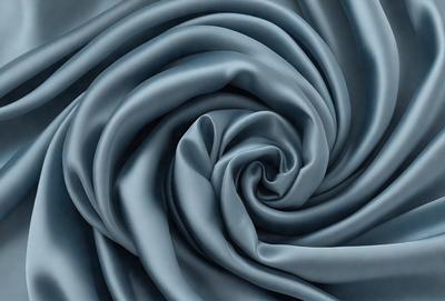 The primary subject of the image is a blue fabric, which appears to be a piece of cloth or a curtain. The setting is a room with a blue background, which complements the blue fabric. The visual style is a close-up of the fabric, showcasing its texture and pattern. The colors and mood of the image are predominantly blue, creating a calm and serene atmosphere.