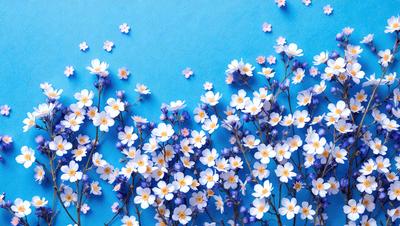 The primary subject of the image is a beautiful blue flower arrangement. The setting is a blue background, which creates a striking contrast with the flowers. The visual style is a close-up of the flowers, showcasing their details and beauty. The colors and mood of the image are predominantly blue, creating a serene and calming atmosphere.