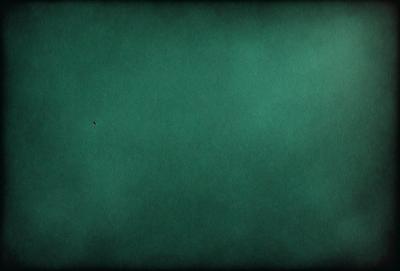 The primary subject of the image is a large, dark green background. The setting is a plain, empty space with no visible objects or people. The visual style appears to be a photo, as it captures a real-life scene. The colors and mood of the image are predominantly dark and moody, with the green background creating a sense of depth and mystery.