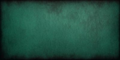 The primary subject of the image is a green background with a texture that resembles a wall or a piece of fabric. The setting is a dark room, and the visual style appears to be a close-up of the green background. The colors and mood of the image are predominantly green, creating a calm and serene atmosphere.