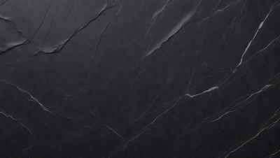 The primary subject of the image is a black marble countertop. The setting is a kitchen, with the countertop being the main focus of the scene. The visual style is a close-up of the marble countertop, showcasing its texture and details. The colors and mood of the image are predominantly dark, with the black marble countertop being the main source of contrast and visual interest.
