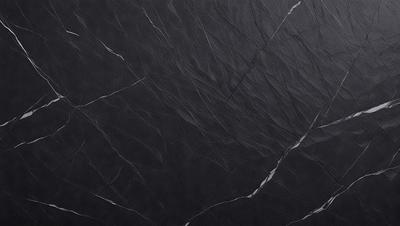 The primary subject of the image is a black marble countertop. The setting is a kitchen, with the countertop being the main focus of the scene. The visual style is a close-up of the marble countertop, showcasing its texture and pattern. The colors and mood of the image are predominantly dark, with the black marble countertop being the main source of contrast.