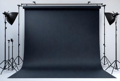 The primary subject of the image is a black screen or curtain, which is the main object in the scene. The setting is a white background, which provides a clean and uncluttered environment. The visual style of the image is a photo, capturing the black screen against the white background. The colors and mood of the image are predominantly black and white, creating a stark and dramatic atmosphere.