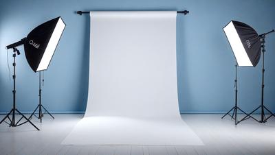 The primary subject of the image is a large white sheet of paper, which is the main object in the scene. The setting is a white wall, and the visual style is a photo. The colors in the image are predominantly white, giving it a clean and minimalist appearance. The overall mood of the image is calm and uncluttered.