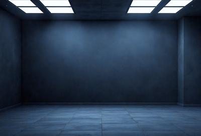 The primary subject of the image is a large, empty room with a blue wall. The setting is a dark room with a blue wall, and the visual style is a photo. The colors and mood of the image are predominantly blue, creating a calm and serene atmosphere.
