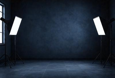 The primary subject of the image is a white light, which is illuminating a dark blue background. The setting is a room with a blue wall, and the visual style appears to be a photo. The colors and mood of the image are predominantly dark and moody, with the white light contrasting against the deep blue background.