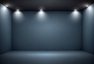 The primary subject of the image is a blue wall with a row of lights shining on it. The setting is a dark room, and the visual style is a black and white photo. The dominant colors are blue and black, creating a moody atmosphere.