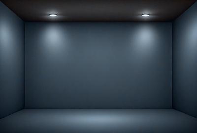 The primary subject of the image is a large, empty room with a blue wall. The setting is a dark room with a blue background, and the visual style is a black and white photo. The colors and mood of the image are predominantly dark and moody, with the blue wall and the overall atmosphere creating a sense of emptiness and solitude.