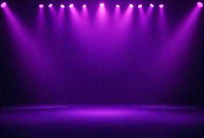 Purple stage lights are shining on a purple stage.